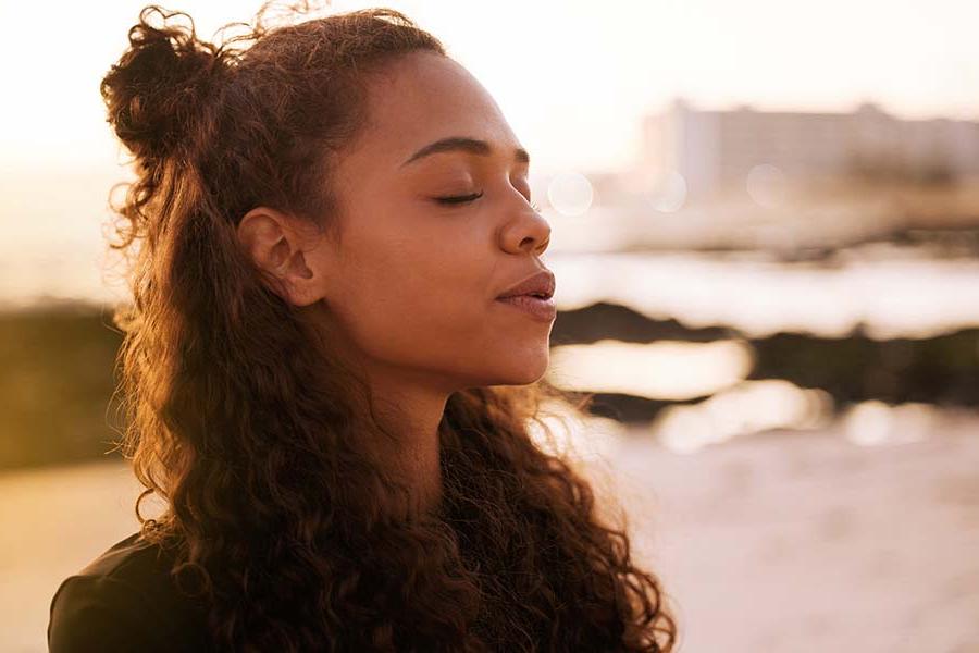 Close-up of young woman with eyes closed, feeling the sunshine